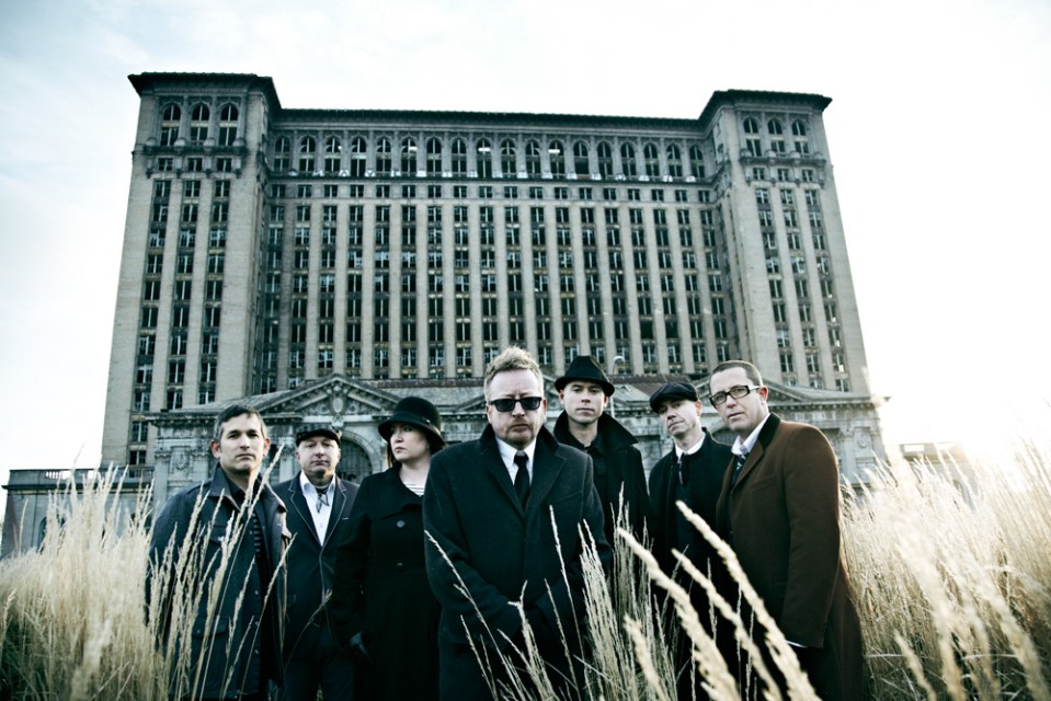 Flogging Molly band photo in front of a large building.