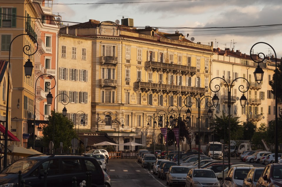 Ajaccio street scene with parked cars and old buildings.