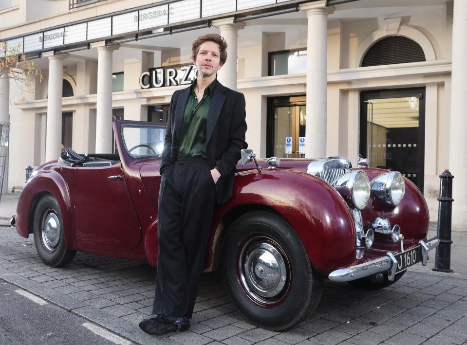 Damien Molony, star of the Bergerac reboot, standing next to a vintage car.