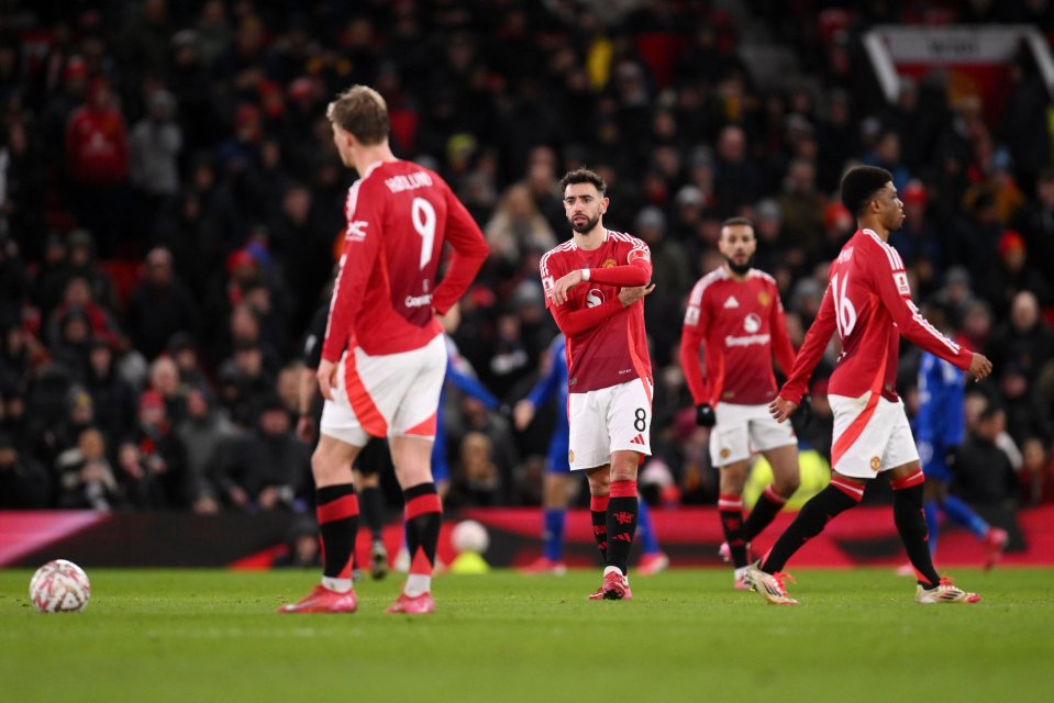 Manchester United players looking dejected on the field.