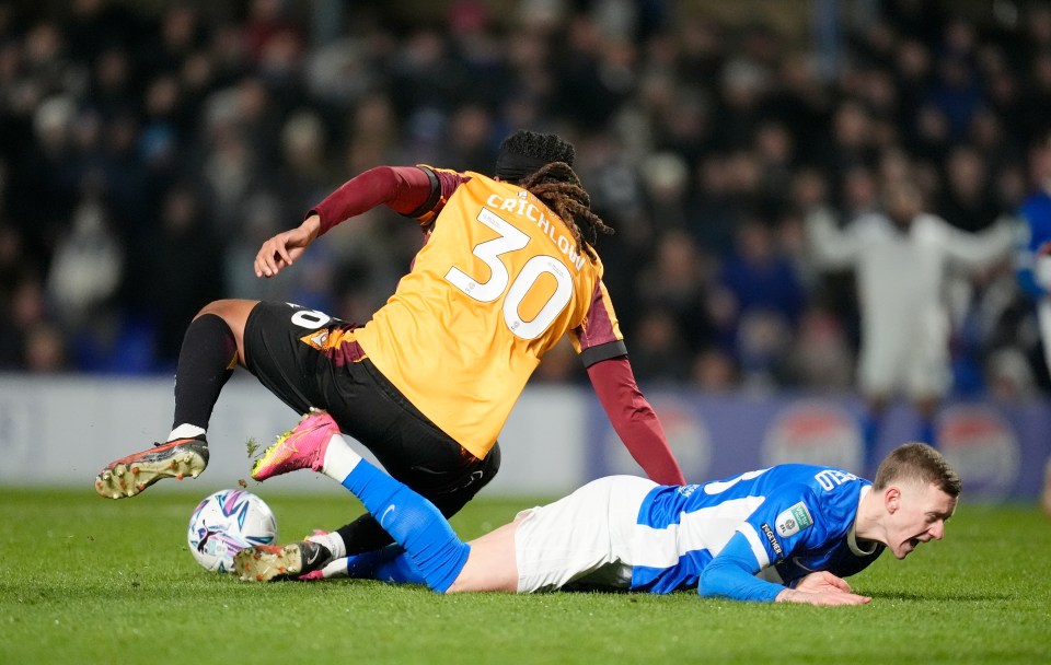 A soccer player is fouled and falls to the ground.