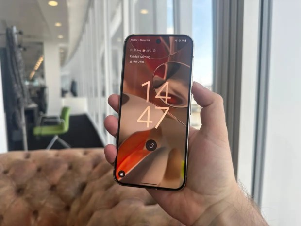 Hand holding Google Pixel 9 XL showing the lock screen.