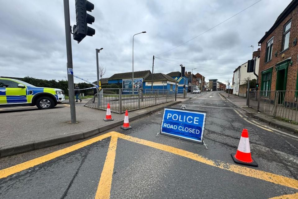 Police road closure sign at accident scene.