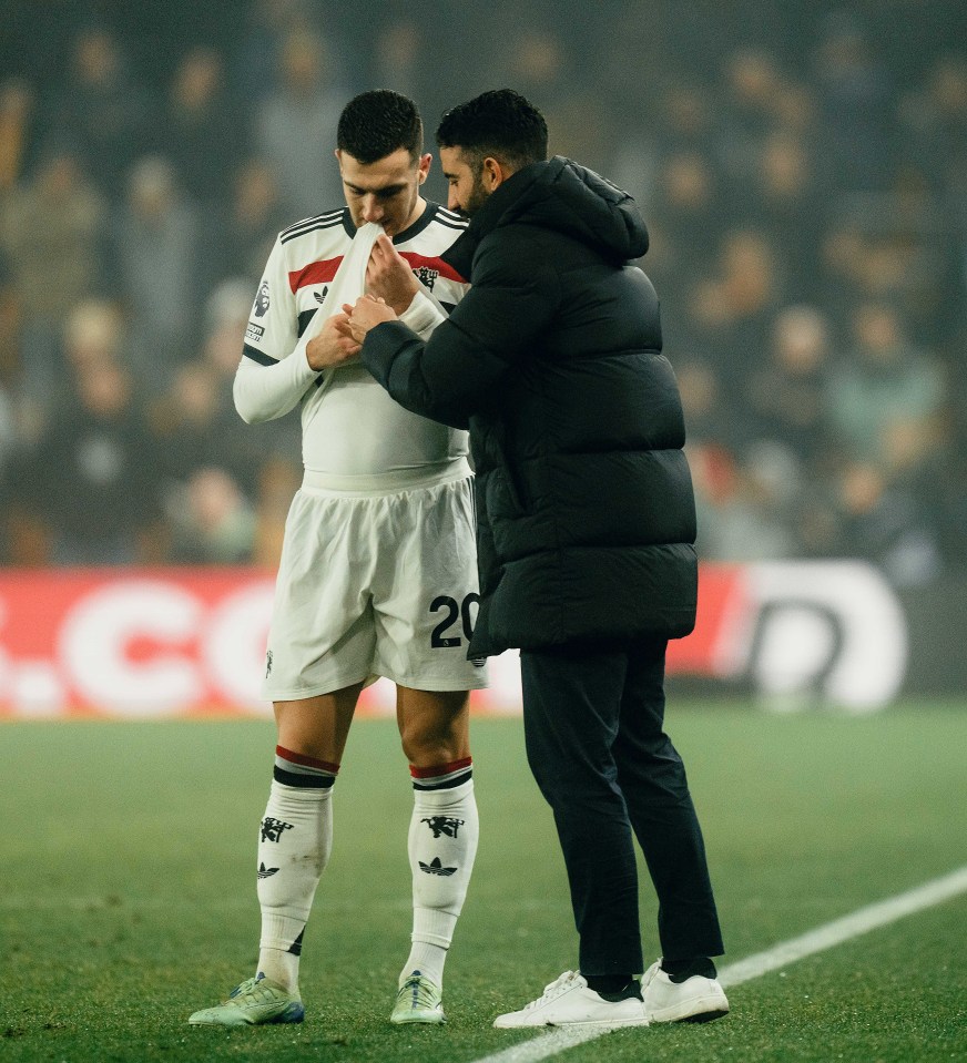 Coach Ruben Amorim speaks with a Manchester United player.