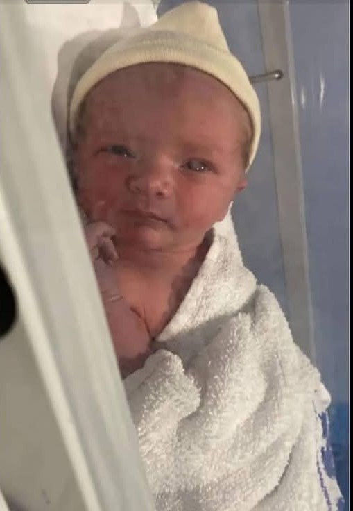 Photo of a newborn baby wearing a knitted hat.