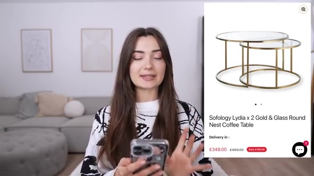 Woman reviewing a gold and glass nesting coffee table online.