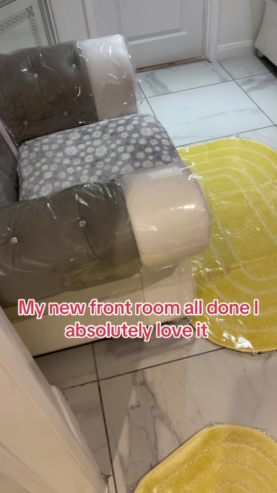 Plastic-covered chair and yellow rugs in a newly decorated room.