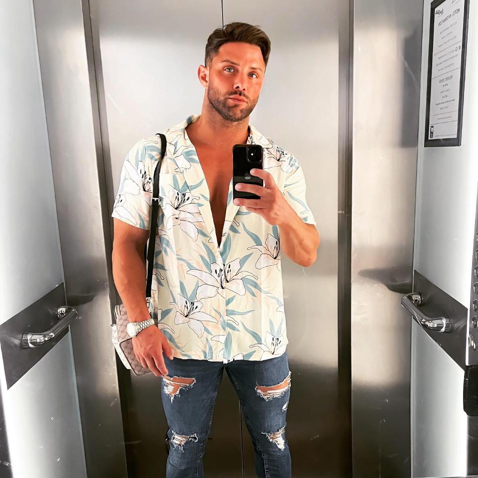 Man in floral shirt taking a selfie in an elevator.