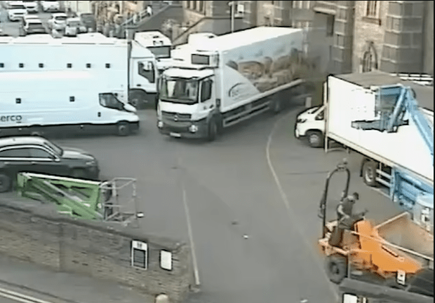 Trucks and other vehicles in a narrow street.