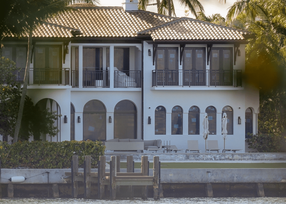 Large white waterfront house with a dock.