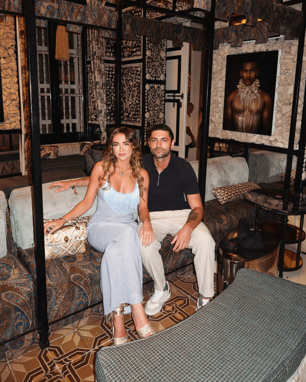 Couple sitting on a couch in a richly decorated room.