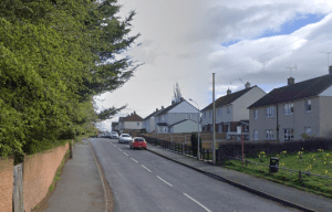 Residential street with cars parked along the side.