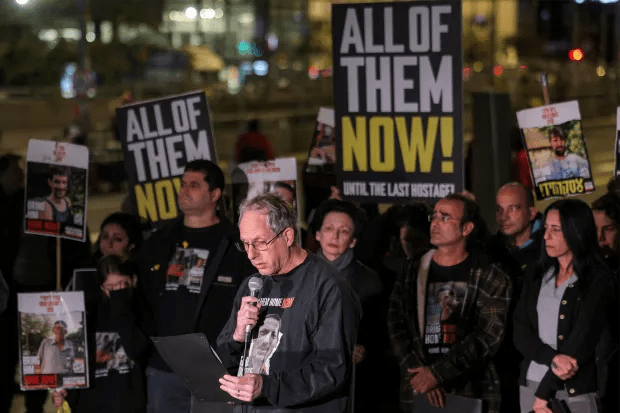 Protestors holding signs demanding the release of hostages.