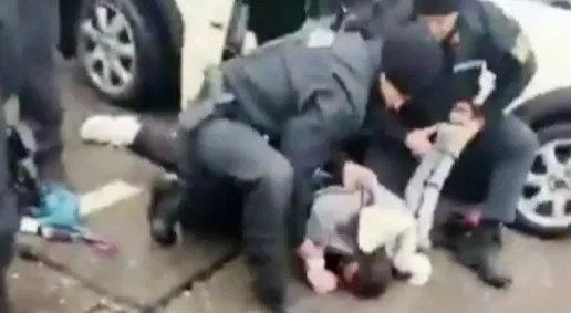 Police officers arresting a person on the ground.