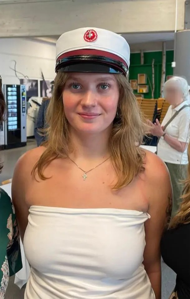 Young woman in graduation cap and white top.