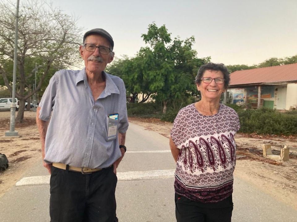 Portrait of an elderly couple standing outdoors.