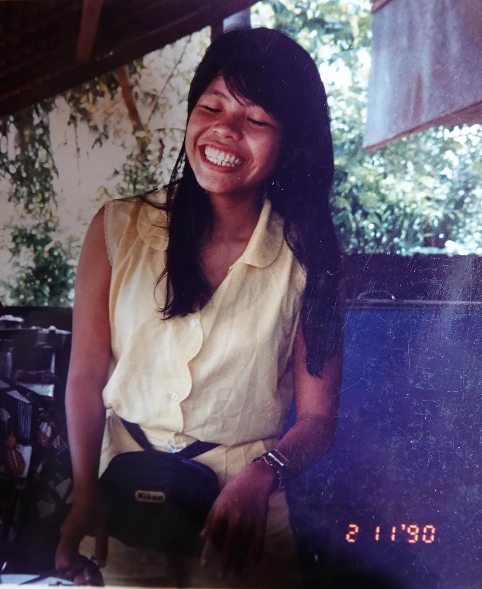 Smiling woman wearing a yellow shirt and fanny pack.