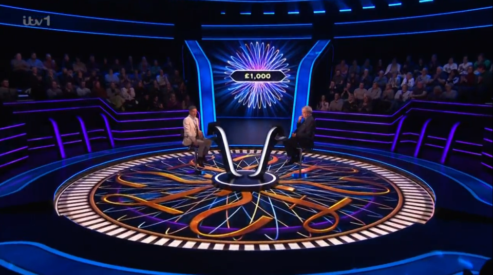 Two contestants on a game show set with a large audience.  £1,000 is displayed on screen.