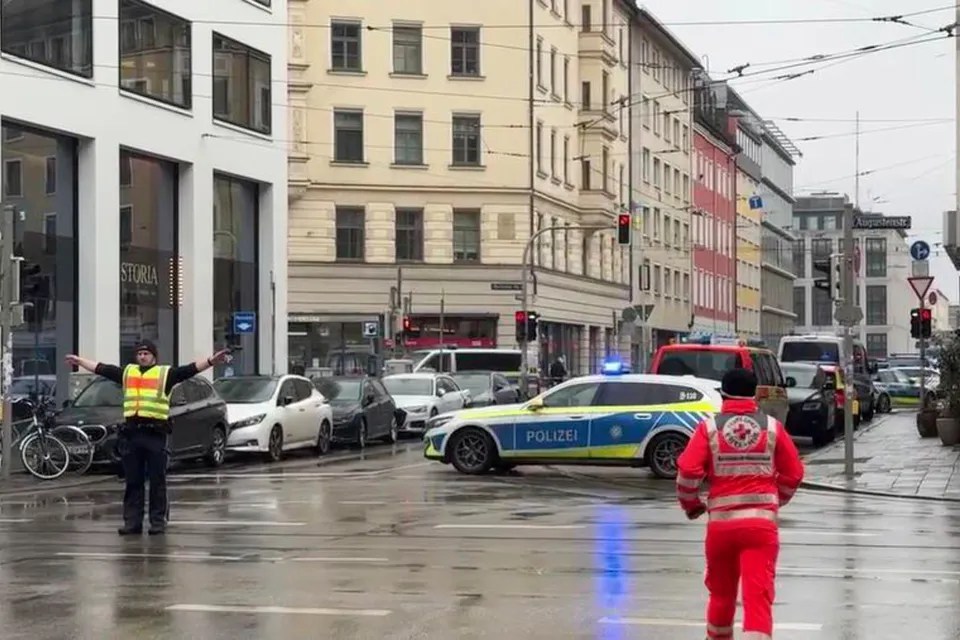 Police car at a city intersection with a police officer directing traffic.