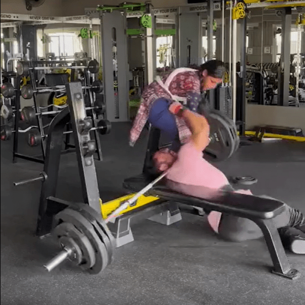 Person failing at bench press in gym.