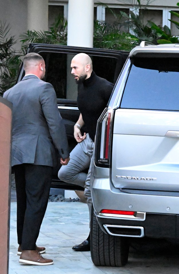 Man exiting a Cadillac Escalade with a bodyguard.