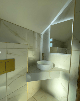 Modern bathroom with marble tiles and gold accents.