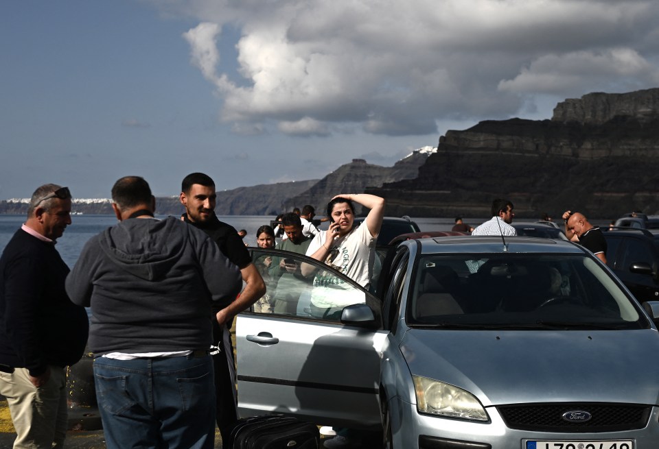 People loading cars onto a ferry.