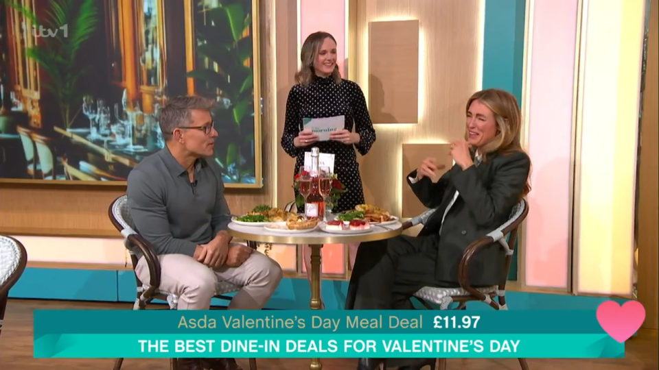 Two people sitting at a table discussing Valentine's Day meal deals.