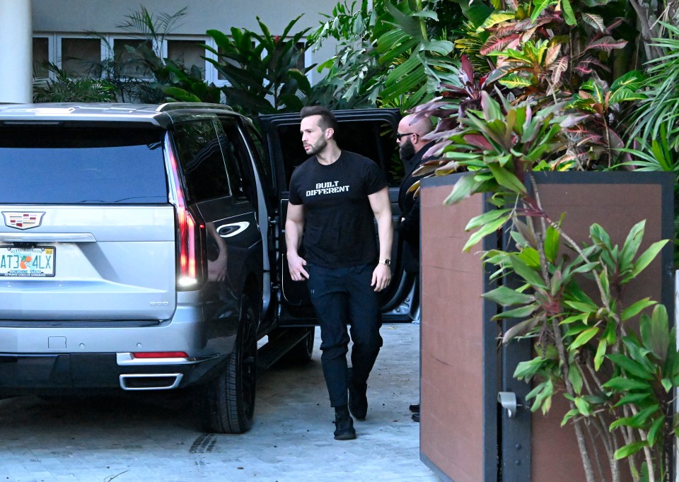 Man in "Built Different" t-shirt exiting a vehicle.