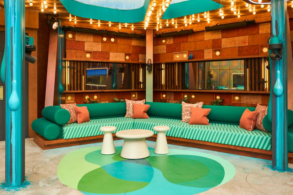 Big Brother garden seating area with teal sofa and patterned rug.