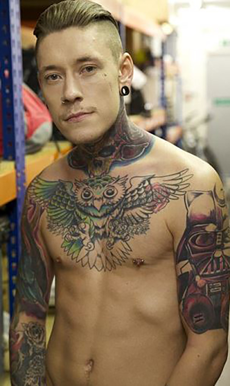 Man with extensive tattoos, including an owl on his chest and Darth Vader on his arm.