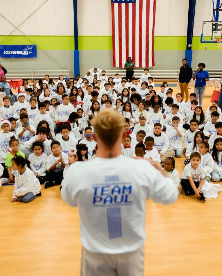 Jake Paul speaking to a large group of children.