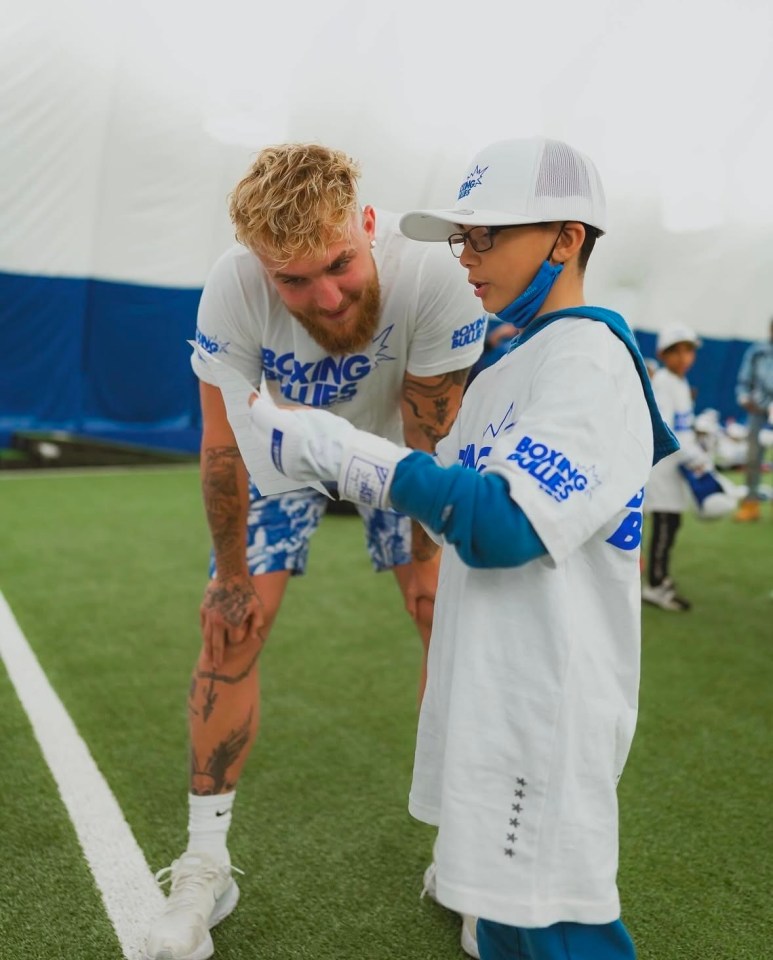 Jake Paul with a child at a Boxing Bullies event.