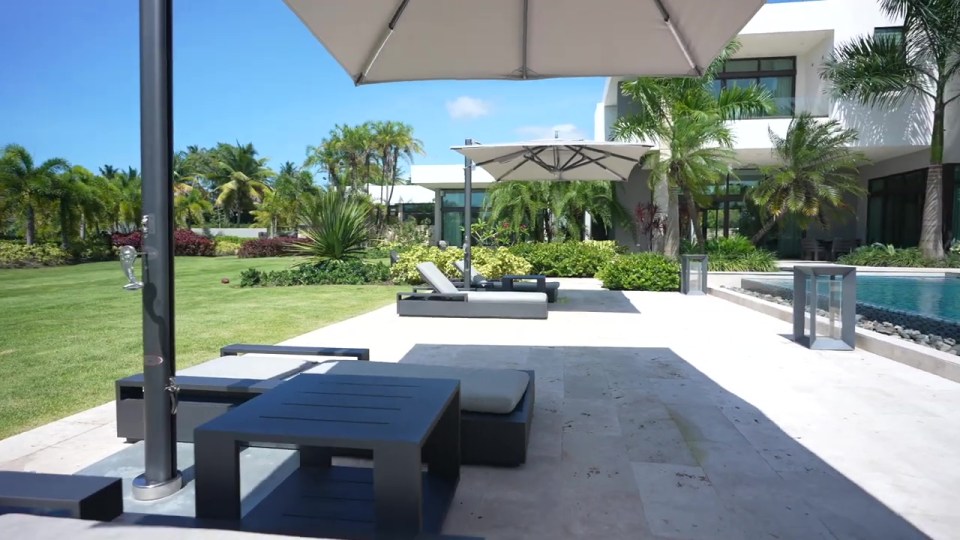 Jake Paul's $13 million island mansion's pool area with lounge chairs and umbrellas.