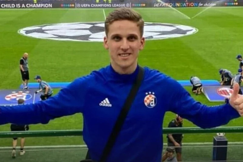 Man in blue Adidas jersey at soccer field giving thumbs up.