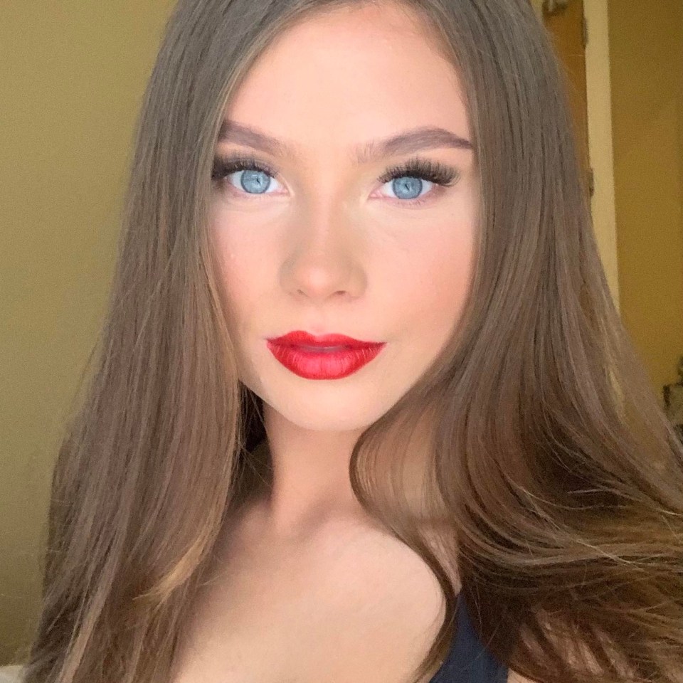 Close-up of a woman with long brown hair and red lipstick.