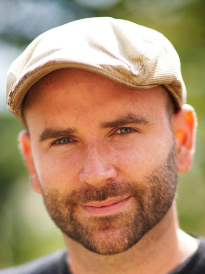 Portrait of a man wearing a newsboy cap.