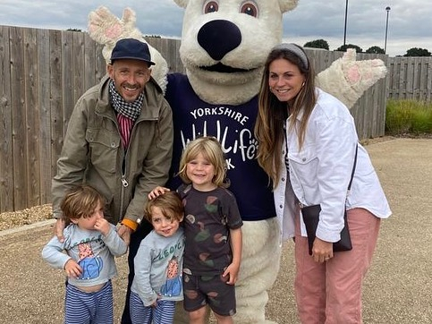 Family with three young children posing with a Yorkshire Wildlife Park mascot.