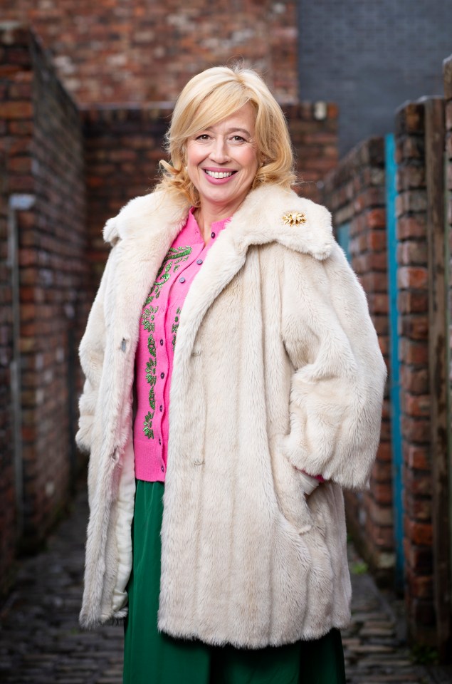 Katy Cavanagh as Julie Carp in a white fur coat.