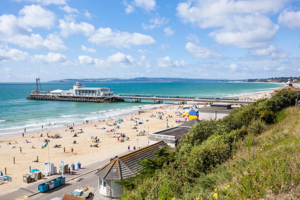 Bournemouth beach with pier and many people.