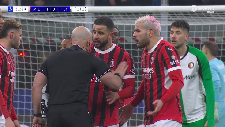 Soccer players arguing with a referee.