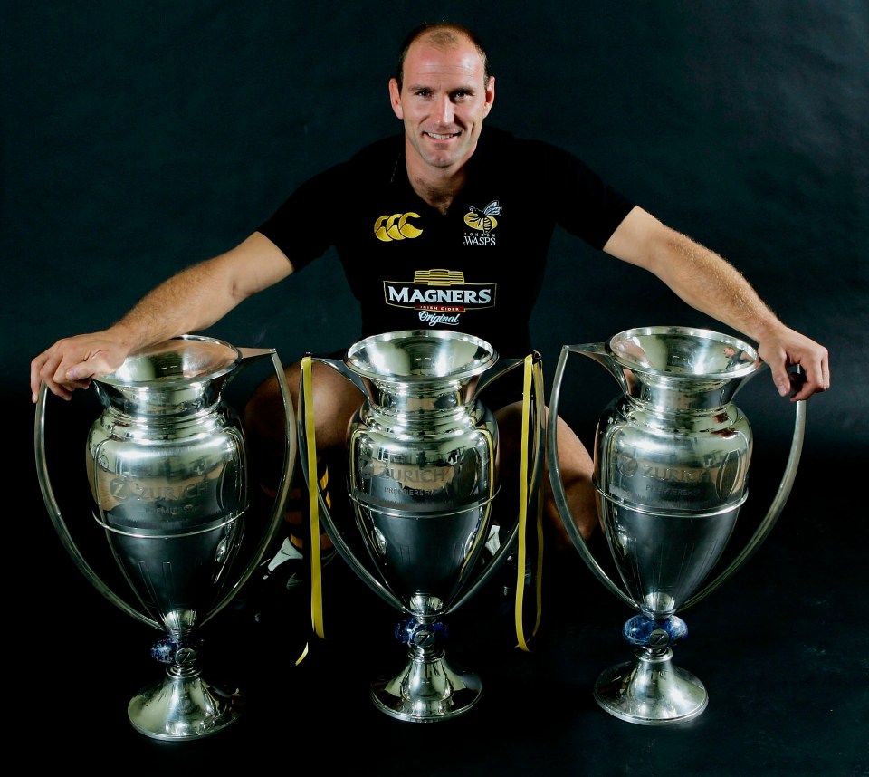 Lawrence Dallaglio, Wasps rugby captain, posing with three Premiership Rugby trophies.