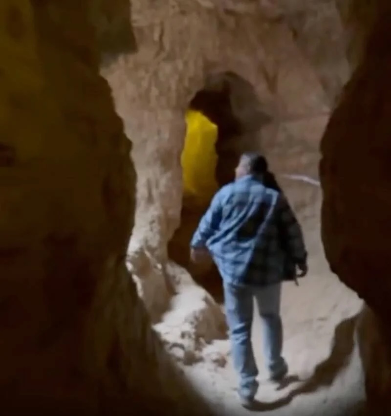 Person walking through an ancient underground labyrinth in Abarkuh, Iran.