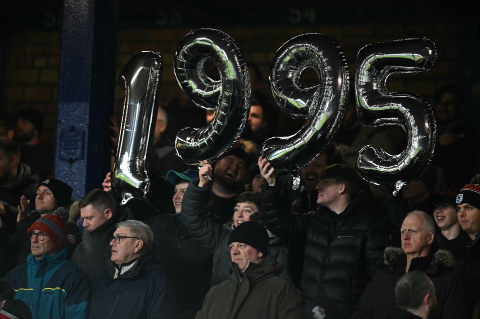 Liverpool fans holding balloons that read "1995" to taunt Everton fans.