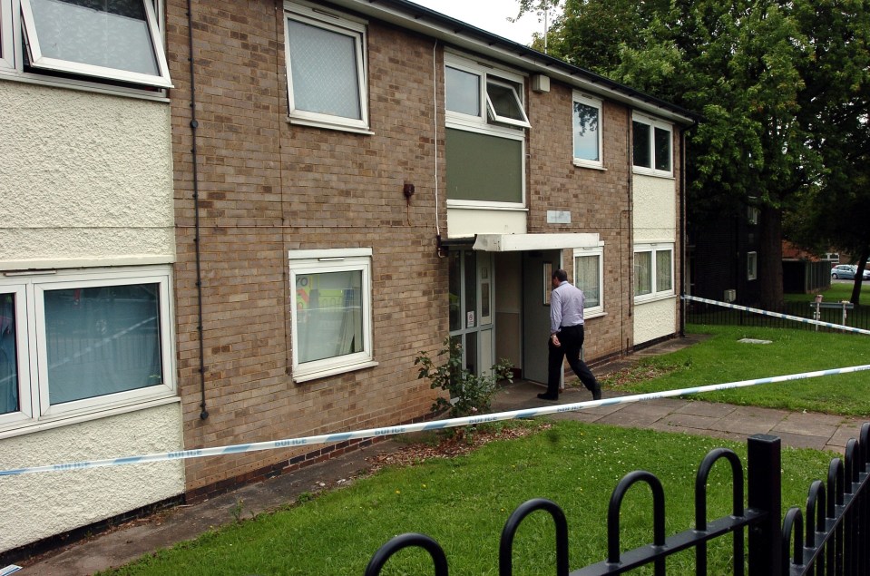 Police at a crime scene outside a brick apartment building.