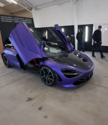 Purple McLaren sports car with doors open.