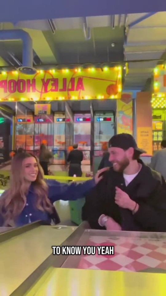 Two Love Island stars playing arcade games.