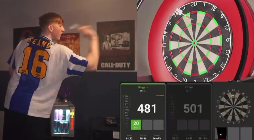 A darts player throws a dart at a dartboard; the score is shown on a digital display.