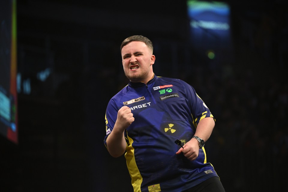 Luke Littler of England celebrates during a darts match.