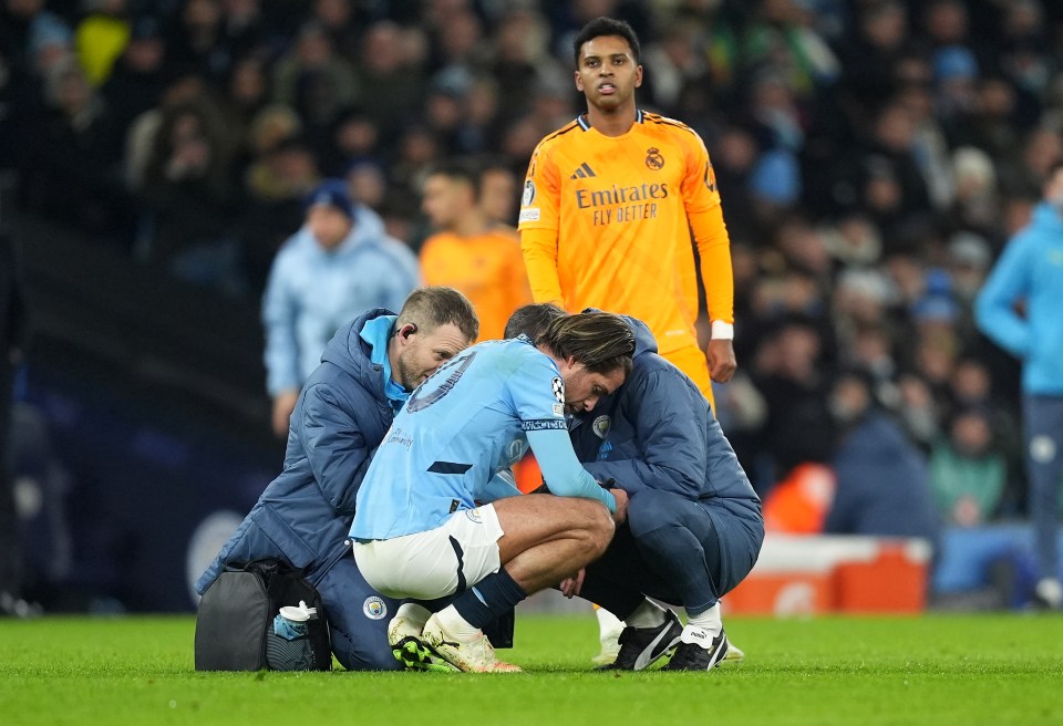 Jack Grealish receiving medical attention on the field.